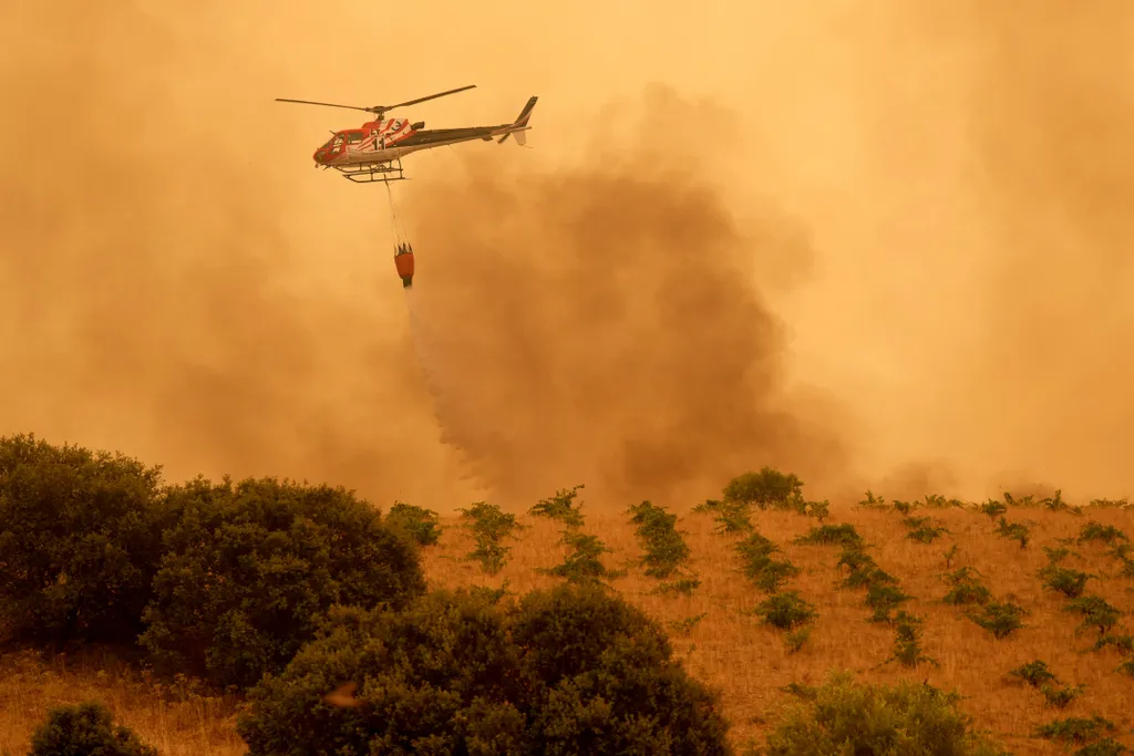 A firefighter helicopter dumps water on a wildfire in Cebreros area, near Avila, 80 kms west of Madrid on July 24, 2026. Spain declared a national emergency in the Madrid region and in the province of Avila, near the capital, on July 23, 2026, in the wake