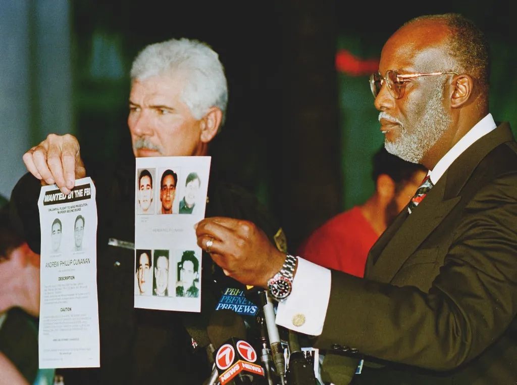 Special Agent for the Federal Bureau of Investigations, FBI Paul Philips (R) and Miami Police Department Chief Richard Barreto (L) show the media FBI fliers picturing Andrew Phillip Cunanan who is the main suspect in the murder of Italian designer Gianni Versace in Miami Beach 15 July 1997. The FBI announced that they have been looking for Cunanan for several other killings in the north of the country. AFP PHOTO Roberto SCHMIDT (Photo by ROBERTO SCHMIDT / AFP)