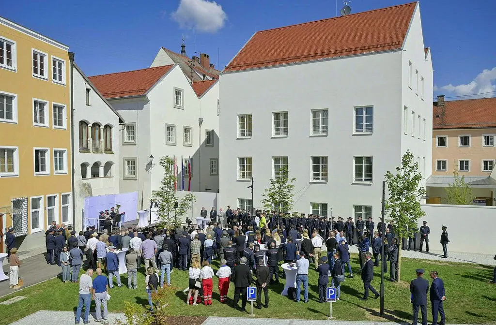 Police officers and guests attend an inauguration ceremony in the courtyard of the birth house of former German dictator Adolf Hitler that is turned into a police station, on July 22, 2026 in Braunau am Inn, Austria. The controversial redesign of the house in the northern Austrian town of Braunau started in 2023. Following years of legal wrangling, the government took control of the dilapidated building in 2016 and decided to turn the house, where Hitler was born in 1889, into a police station that will be inaugurated on July 22, 2026. (Photo by MANFRED FESL / APA / AFP) / Austria OUT