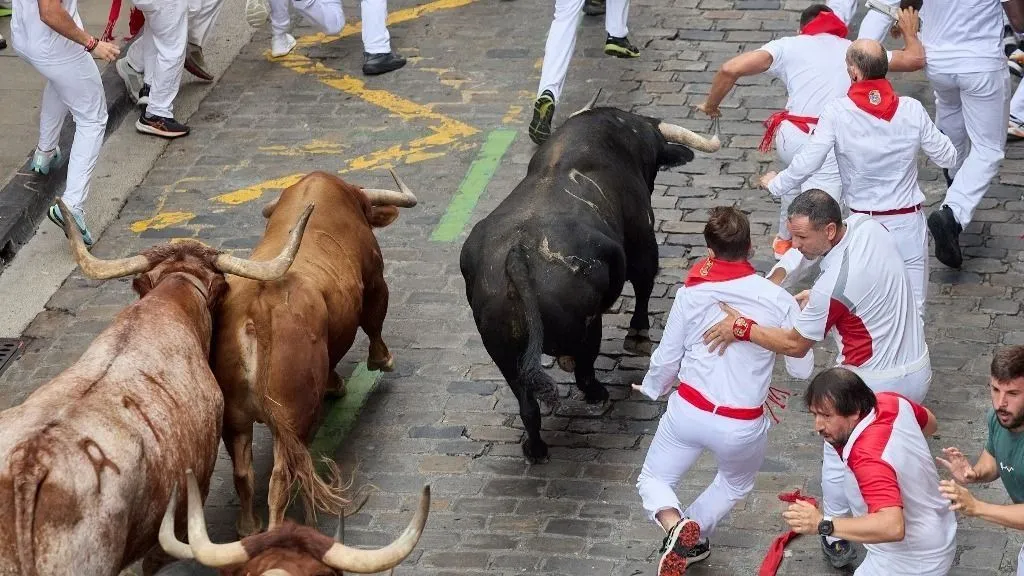 Az elszabadult bika átugrotta az aréna kerítését, majd a menekülő tömegnek rontott KolumbiábaPAMPLONA, SPAIN - JULY 09: Participants wearing traditional white outfits and red scarves take part in the running with the bulls event, known as 'Encierro,' during the San Fermin Festival in Pamplona, northern Spain, on July 09, 2026. The adrenaline-filled run covers an 875-meter stretch through the historic city center. Ruben Albarran / Anadolu (Photo by Ruben Albarran / Anadolu via AFP)