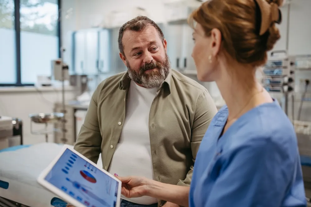 Laborvizsgálat után koleszterinszintet kielemző orvos és páciens