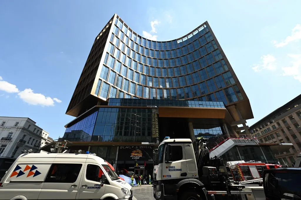 holttest, This photograph shows a general view of the OXY Tower housing complex where a fatal fire broke out in Brussels on July 14, 2026. The Brussels Labour Inspectorate said several bodies had been found in the building's lift shafts, while six people remained missing. The fire broke out on the second floor of the building, which was undergoing renovation. (Photo by EMILE WINDAL / Belga / AFP) / Belgium OUT