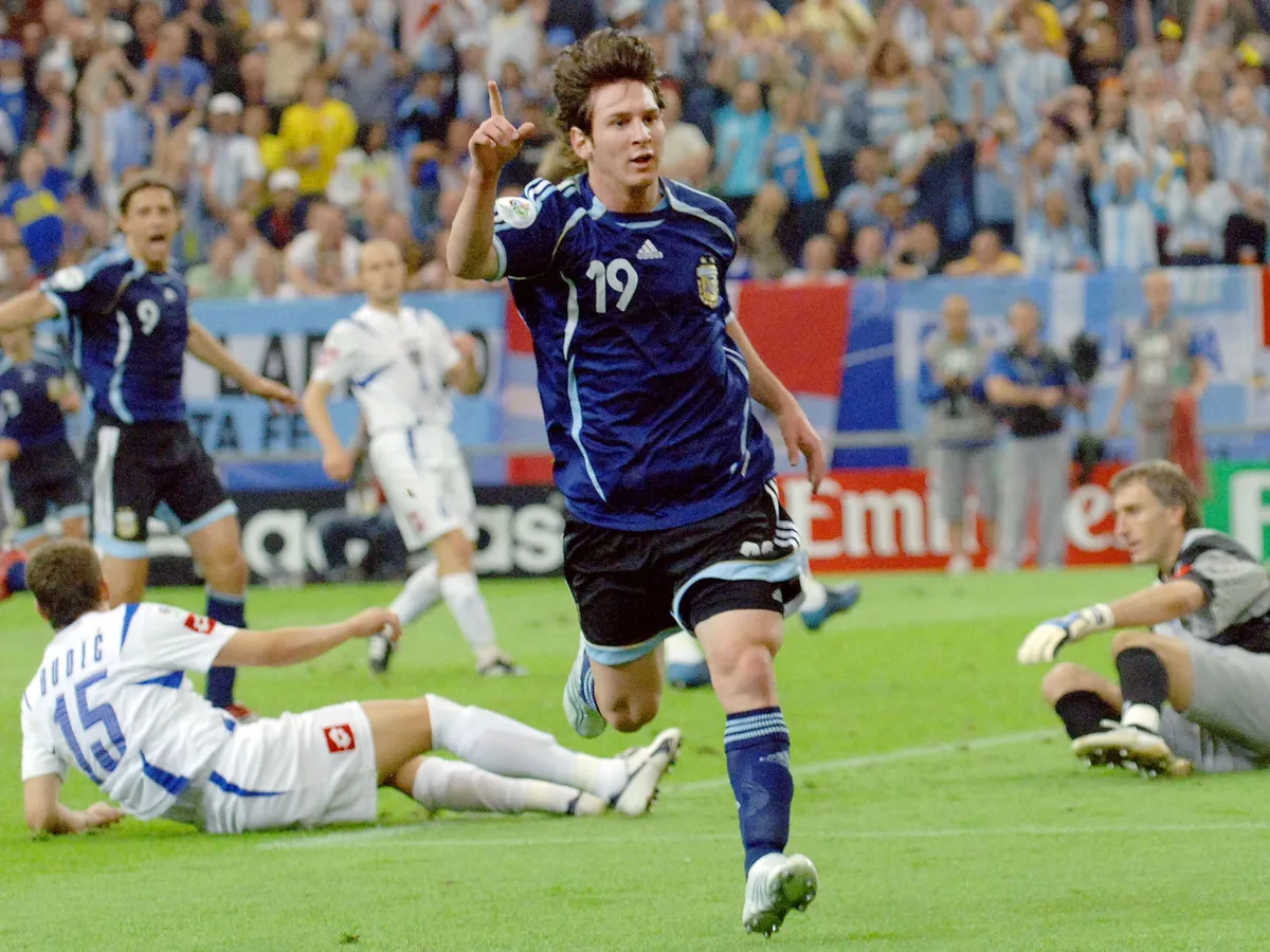 Argentinian forward Lionel Messi celebrates after scoring as Serbia and Montenegro's goalkeeper Dragoslav Jevric (R) and Serbia and Montenegro's defender Milan Dudic (15) react during the FIFA World Cup 2006 group C World Cup football match Argentina vs Serbia-Montenegro, 16 June 2006 at Gelsenkirchen stadium. Argentina won 6-0. AFP PHOTO JUNG YEON-JE (Photo by JUNG YEON-JE / AFP)