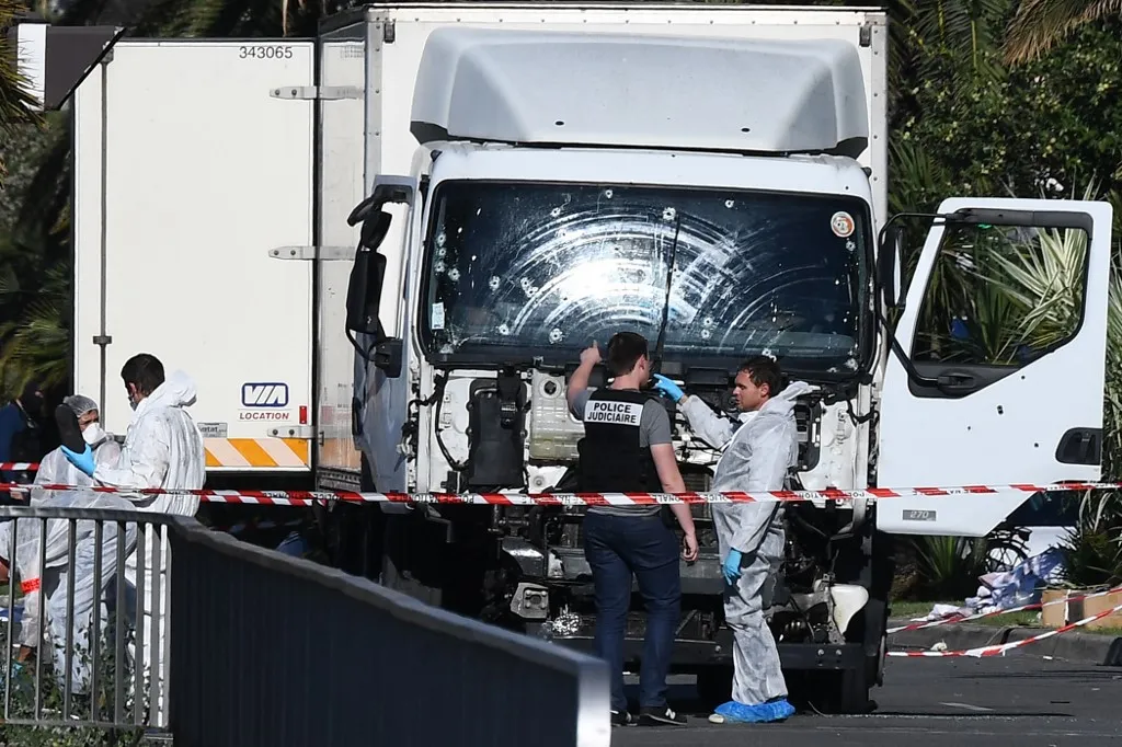 Terrortámadások Európában: a nizzai merénylet és a kontinens véres terrorhulláma, (FILES) Forensics officers and policemen look for evidences near a truck on the Promenade des Anglais seafront in the French Riviera town of Nice on July 15, 2016, after it drove into a crowd watching a fireworks display. Ten years after the attack that killed 86 people and injured more than 400 on July 14, 2016, on Nices Promenade des Anglais, the city is preparing to pay tribute to the victims. (Photo by ANNE-CHRISTINE POUJOULAT / AFP)