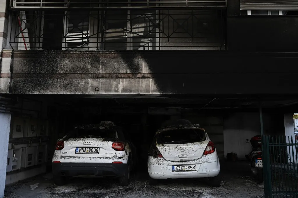 This photograph shows a view of the damage after a gas canister bomb exploded at the entrance of a building in Thessaloniki on July 1, 2026. Five people were injured and extensive damage was caused by three coordinated incendiary attacks using improvised gas canister bombs targeting the homes of three leaders of Greeces ruling New Democracy party. (Photo by Sakis Mitrolidis / AFP)