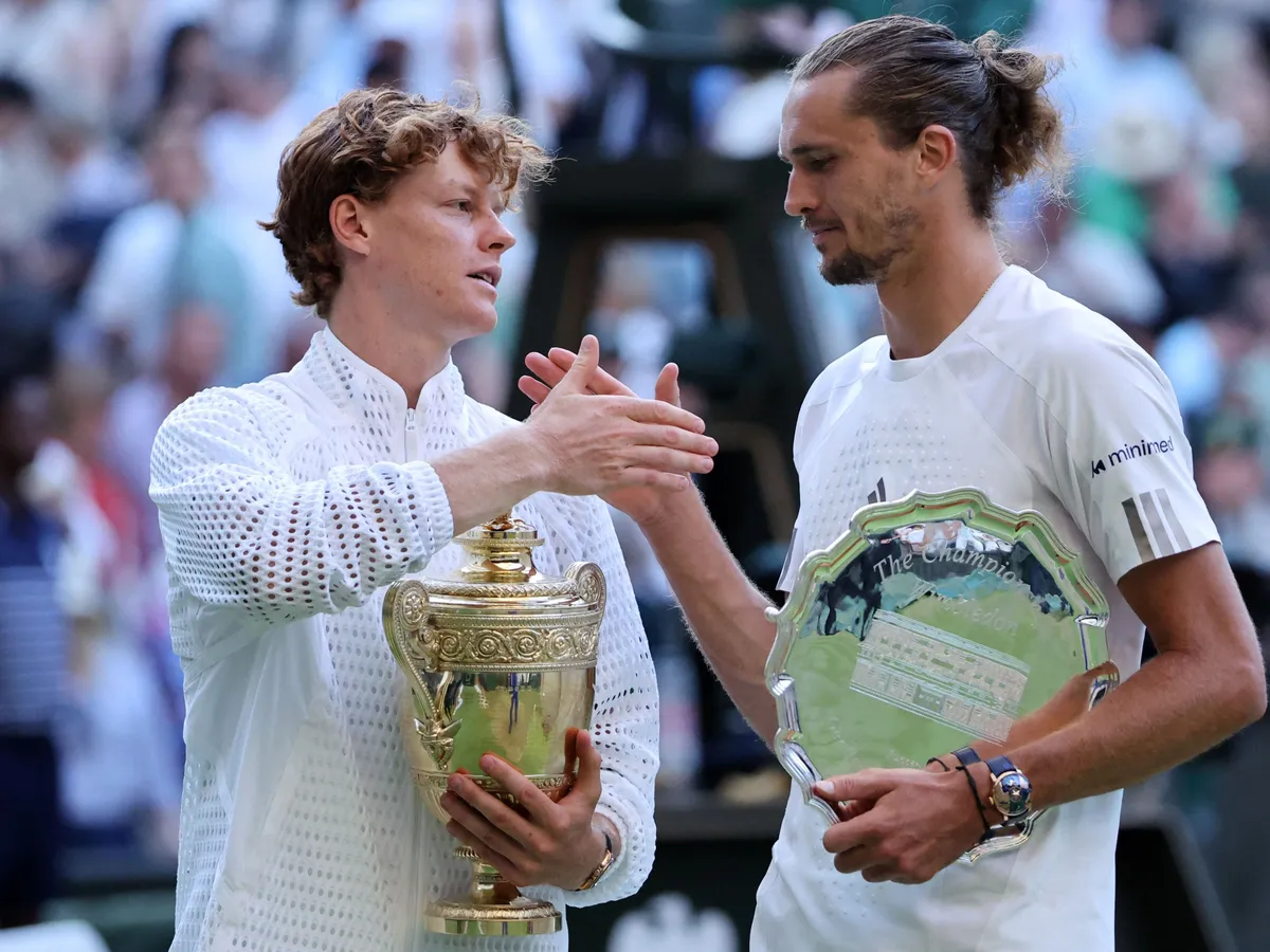 Italy's Jannik Sinner (L) holds the Gentlemen's Singles Trophy after winning the men's singles final tennis match against Germany's Alexander Zverev (R) on the last day of the 2026 Wimbledon Championships at The All England Lawn Tennis and Croquet Club in Wimbledon, southwest London, on July 12, 2026. (Photo by Henry NICHOLLS / AFP) / RESTRICTED TO EDITORIAL USE
