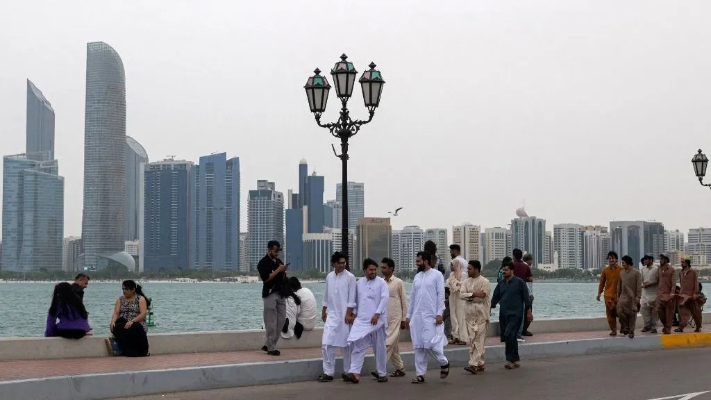 People walk along the corniche area on the occasion of Eid al-Fitr, marking the end of the holy month of Ramadan, in Abu Dhabi on March 20, 2026. (Photo by Ryan Lim / AFP)