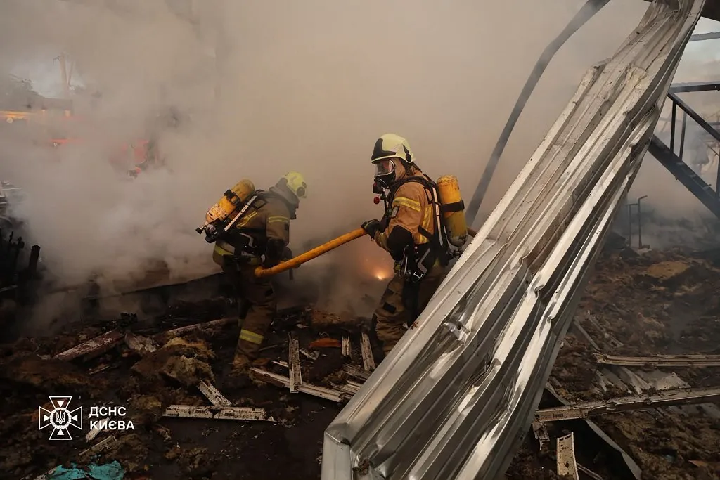 This handout photograph taken and released by Ukrainian State Emergency Service on July 11, 2026 shows firefighters extinguishing a fire in warehouse damaged following  Russian missile strikes on the Ukrainian capital of Kyiv early on July 11, 2026, amid the Russian invasion in Ukraine. Ukraine said Russian missile strikes on Kyiv wounded six people, as Moscow escalates attacks on the Ukrainian capital. AFP journalists in Kyiv heard two series of explosions in the early hours of Saturday, with an air alert siren sounding minutes after the first blast. (Photo by Handout / Ukrainian State Emergency Service / AFP)