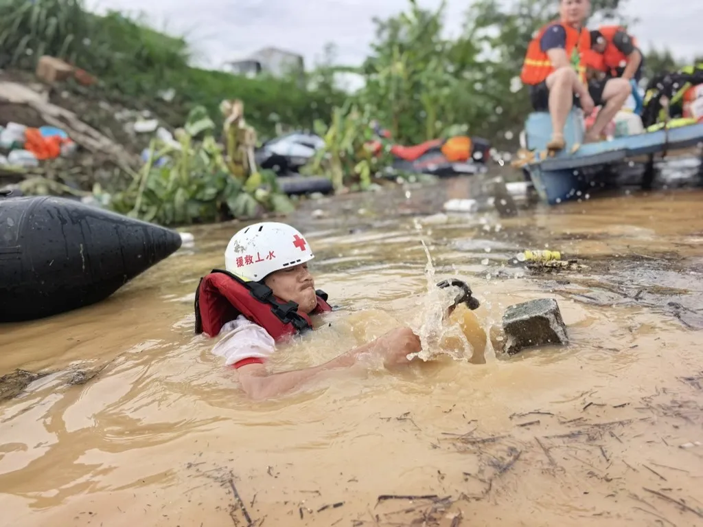 (260707) -- BINYANG, July 7, 2026 (Xinhua) -- Rescuers remove fences to allow rescue boats to pass through in Gantang Town, Binyang County of Nanning, south China's Guangxi Zhuang Autonomous Region, July 7, 2026. Recent extreme rainstorms triggered by Typhoon Maysak, the 10th typhoon of the year, have caused severe flooding in parts of south China's Guangxi Zhuang Autonomous Region. (Xinhua) (Photo by Jin Liangkuai / Xinhua via AFP)
