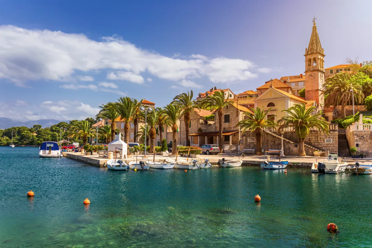 Horvátország mediterrán tengerpartja kikötővel és házakkal.