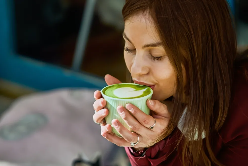 Friss matcha teát fogyasztó nő