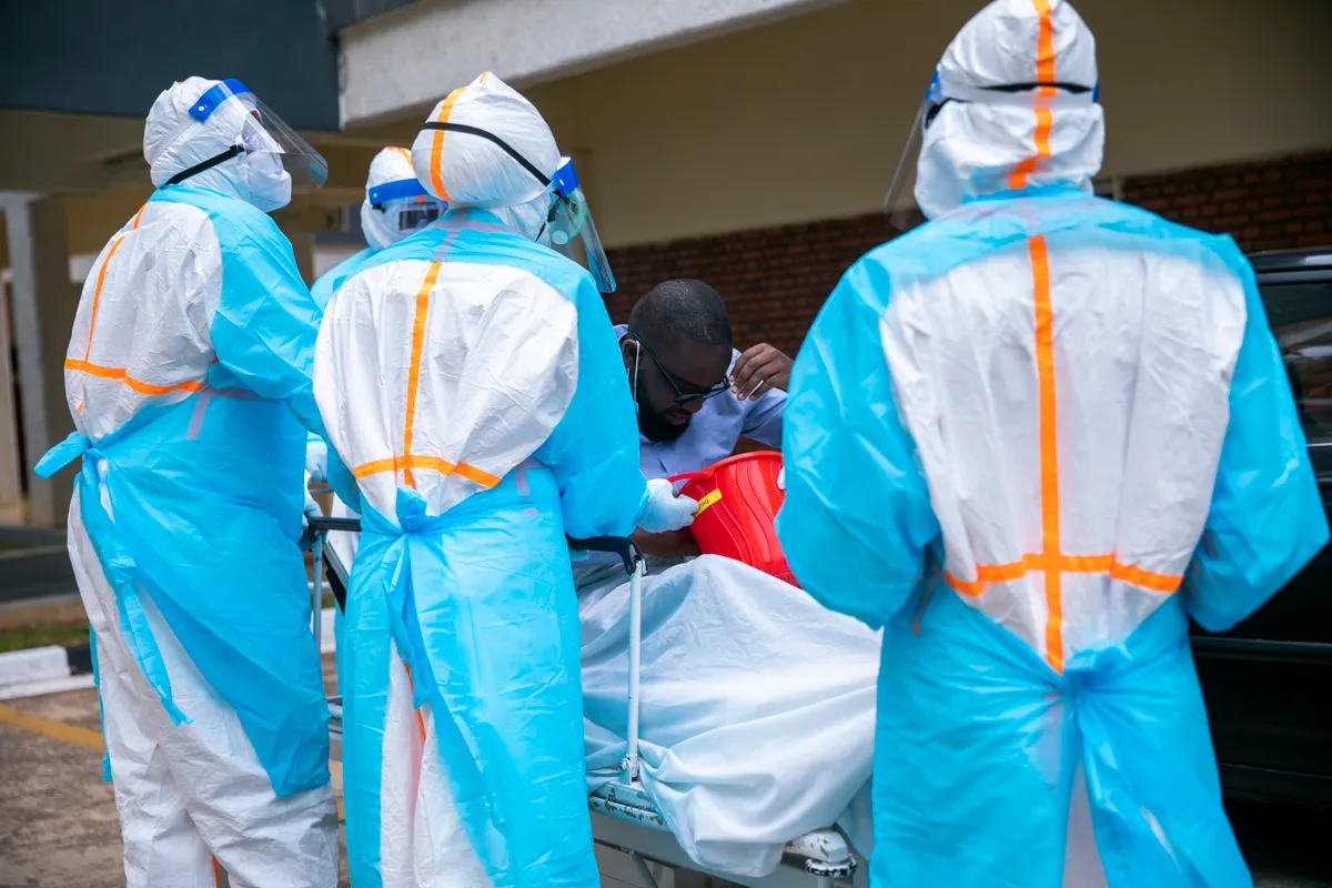 Ebola vírusban elhunyt beteg körül beöltözött orvosok