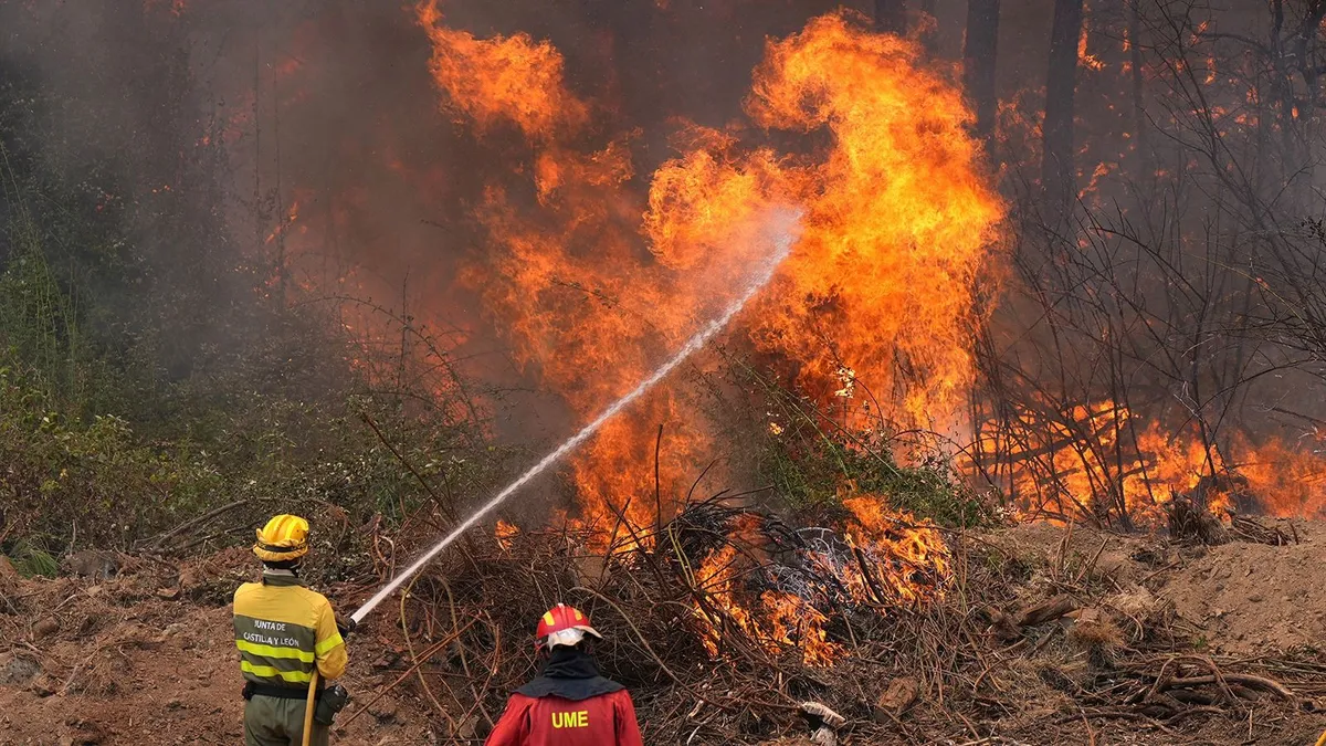 spanyolországi erdőtűz, Spain's Military Emergencies Unit (UME) and Castilla-y-Leon unit's firefighters battle a fire in a forest next to La Atalaya residential area in El Tiemblo, 80 kms west of Madrid, on July 25, 2026 amid wildfires that have burned up to 25,000 hectares. Spanish firefighters hoped to get control of wildfires raging near Madrid on Saturday but an official warned that erratic winds threatened to fan the blazes further. The worst wildfires in the Madrid region's history rage west of the Spanish capital, forcing authorities to evacuate or order around 60,000 people to remain indoors. (Photo by Cesar MANSO / AFP)