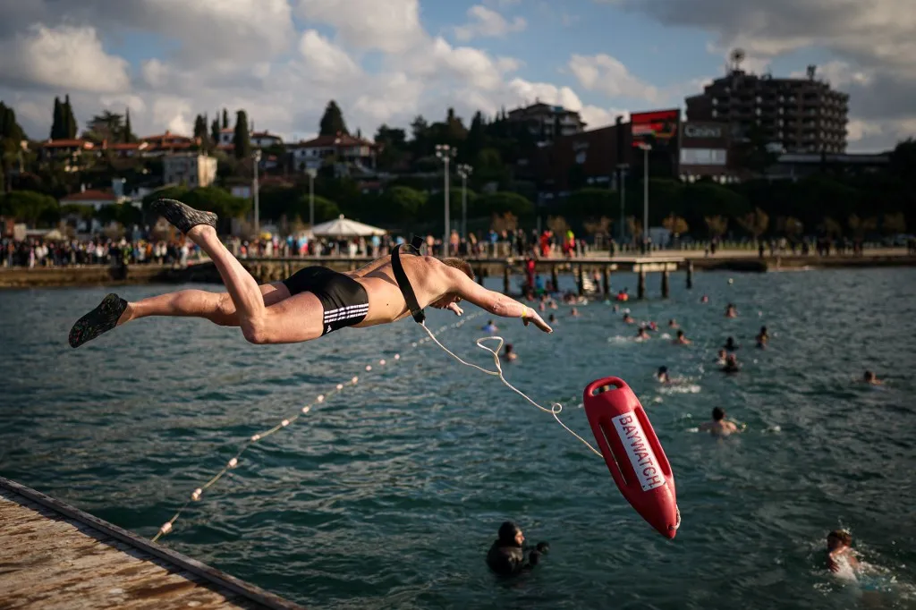 A man dives into the water during the traditional New Year's Jump in the Adriatic Sea in Portoroz, on January 1, 2026. (Photo by Jure Makovec / AFP)