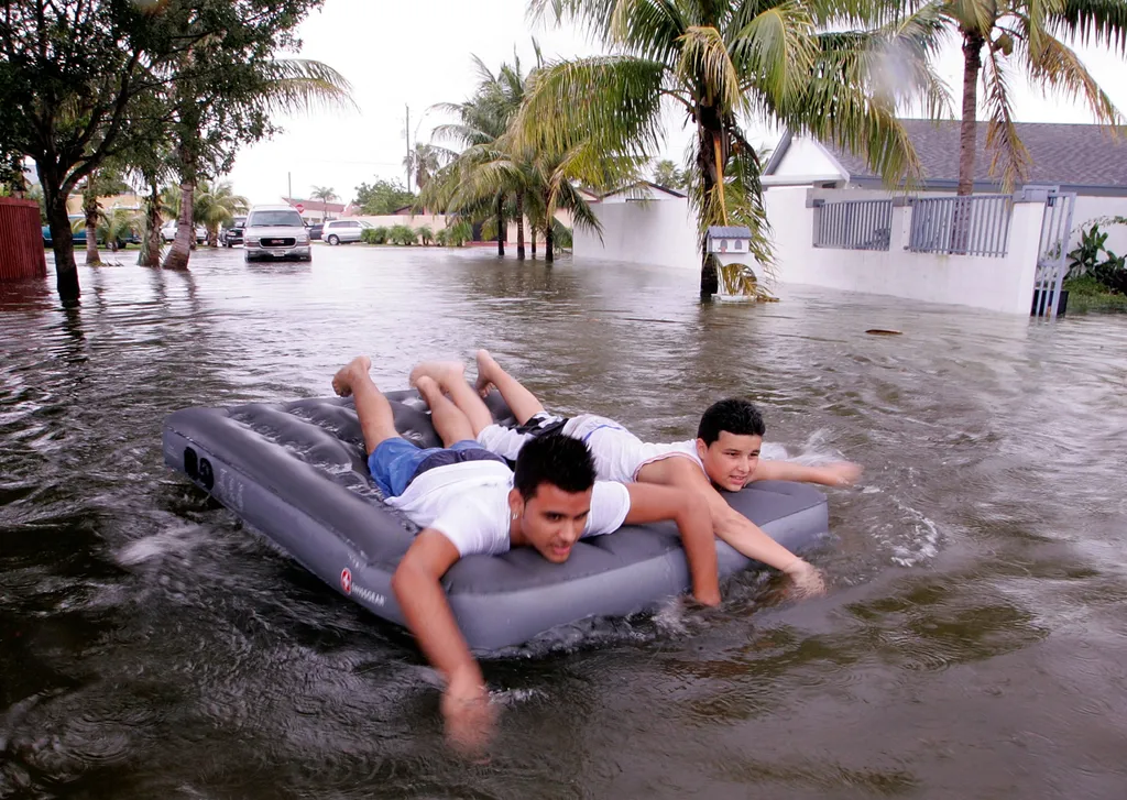 Katrina hurrikán, Katrinahurrikán, New Orleans, 2005, Katrina hurrikán 2005,
Friends Wilfredo Lopez (L) and Orlando Maderos paddle an air mattress down their street after Hurricane Katrina dumped as much as 15 inches of rain as it passed over this communi