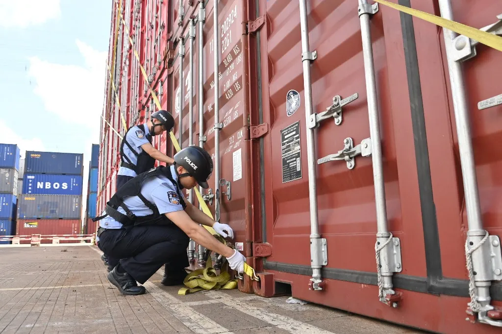 (260807) -- BEIJING, Aug. 7, 2026 (Xinhua) -- Police officers secure containers at a container yard ahead of a typhoon in Beilun District of Ningbo City, east China's Zhejiang Province, on Aug. 7, 2026.
China's National Meteorological Center issued a yellow alert on Thursday evening, forecasting Typhoon Dolphin to make landfall along China's eastern coast between Shanghai and Fuqing in Fujian Province on Sunday or Monday, with an intensity ranging from typhoon to severe typhoon level, bringing heavy rain to areas north of the landfall site.
Local authorities along China's eastern coast have taken various measures, so as to effectively protect the safety of people's lives and property. (Photo by Hu Jiajie/Xinhua) (Photo by Hu Jiajie / Xinhua via AFP)