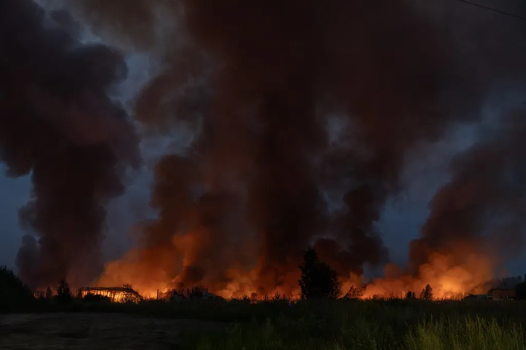 This photograph shows fire and smoke rising from a warehouse destroyed during massive Russian ballistic missile and drone strikes on the outskirts of Kyiv early on August 5, 2026, amid the Russian invasion of Ukraine. Russian strikes on Ukraine's capital and surrounding region killed at least two people and wounded dozens more, authorities said on August 5, 2026, after fresh overnight missile and drone attacks. (Photo by Roman PILIPEY / AFP)
