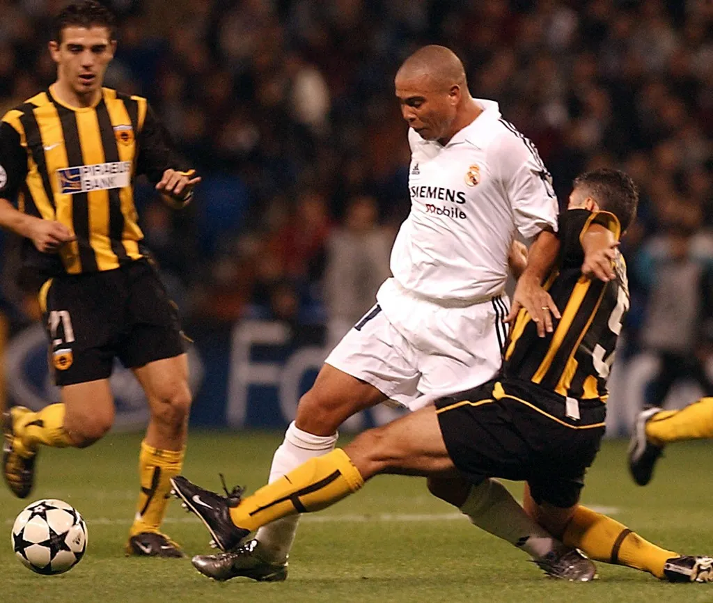 Real Madrid's Brazilian , Ronaldo (C) fights for the ball with AEK Athens Nikolaos Kostenoglou (R), under the eyes of Konstantinos Katsouranis during their  Champion's League  match in Madrid 22 October 2002.  AFP PHOTO/Pierre-Philippe MARCOU (Photo by Pierre-Philippe MARCOU / AFP)