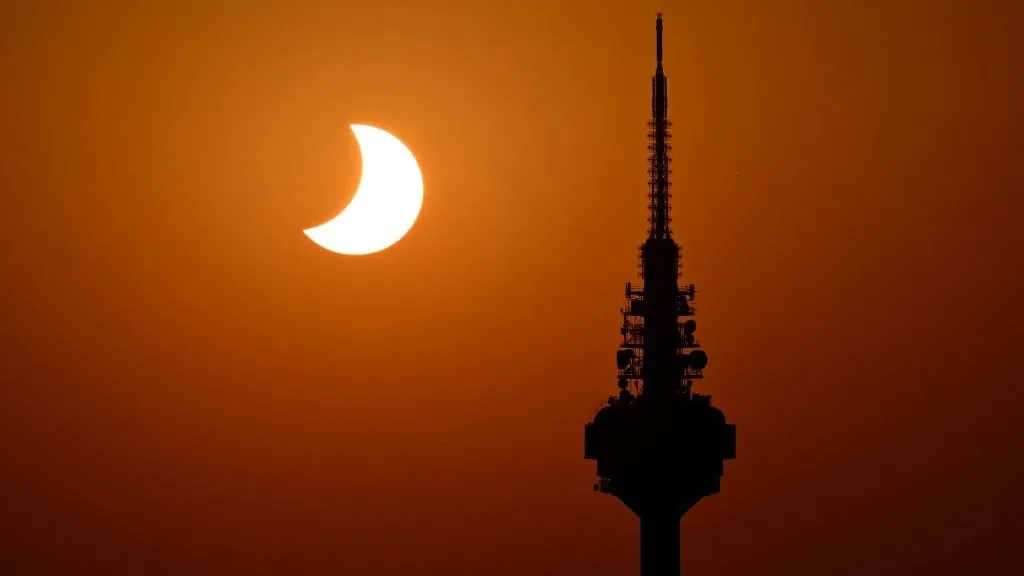napfogyatkozás, The Moon uncovers the Sun behind Torrespana TV tower, nicknamed "El Piruli", in the last moments of the solar eclipse as seen from the Cuna Verde viewpoint in Madrid, on August 12, 2026. Millions of Europeans contemplated the sky in awe today during a rare total solar eclipse that will plunge a swathe of Spain into an eerie daytime darkness. The shadow cast when the Moon covers the Sun began in Russia's remote Arctic north at around 1700 GMT and continued in an arc through Greenland and Iceland. Spain is where most people viewed the total eclipse, which crossed the country diagonally from the northern Atlantic coast to the Mediterranean Sea, where it vanished at around 1830 GMT. (Photo by JAVIER SORIANO / AFP)