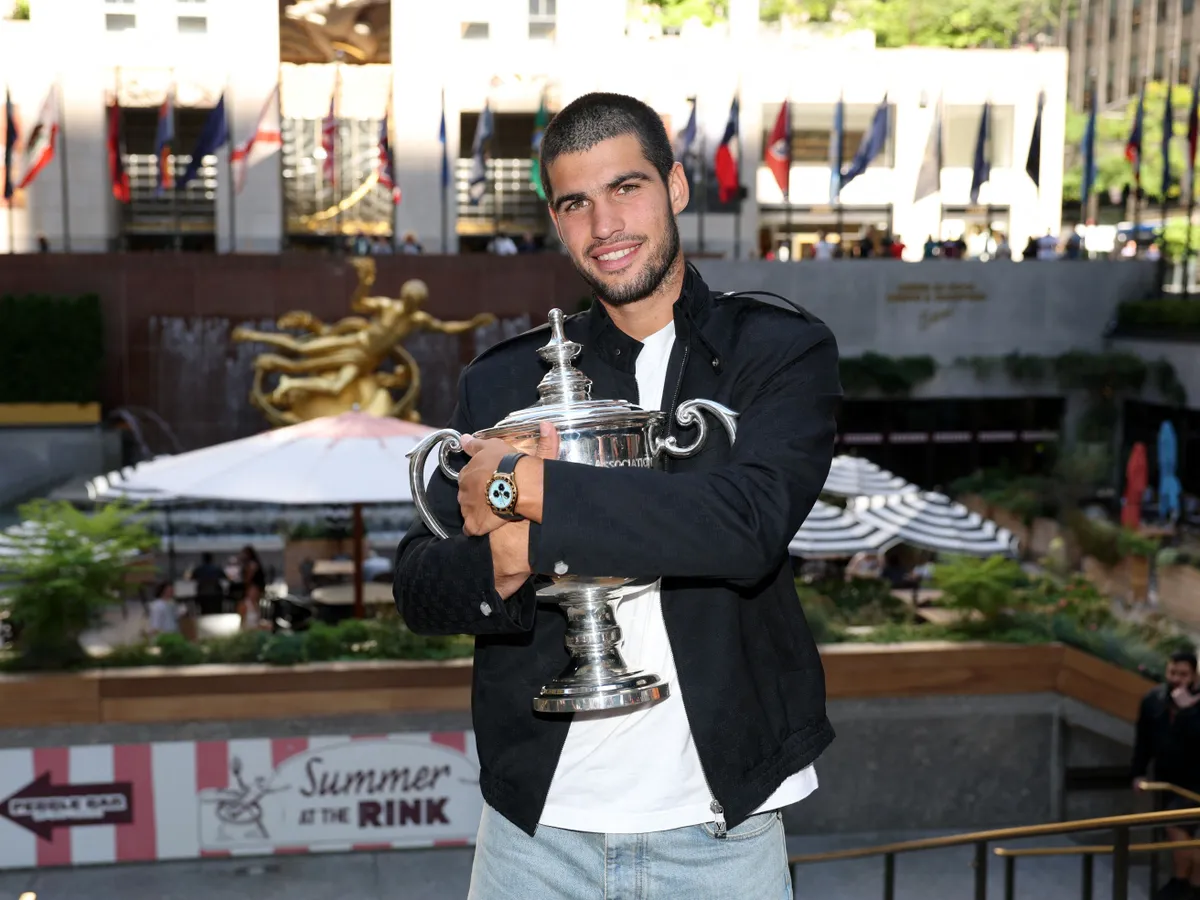NEW YORK, NEW YORK - SEPTEMBER 08: US Open 2025 Champion Carlos Alcaraz of Spain poses for a photo overlooking Rockefeller Plaza with the Men's Singles trophy following his victory over Jannik Sinner of Italy in the Men's Singles Final on September 08, 2025 in New York City.   Clive Brunskill/Getty Images/AFP (Photo by CLIVE BRUNSKILL / GETTY IMAGES NORTH AMERICA / Getty Images via AFP)
