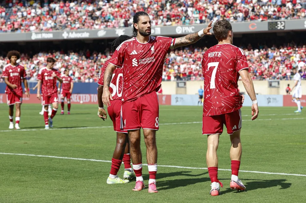 Liverpool's German midfielder #07 Florian Wirtz (R) is congratulated by Liverpool's Hungarian midfielder #08 Dominik Szoboszlai (C) after scoring during the first half of the pre-season friendly football match between Liverpool FC and Leeds United FC at Soldier Field in Chicago, Illinois, on August 2, 2026. (Photo by KAMIL KRZACZYNSKI / AFP)