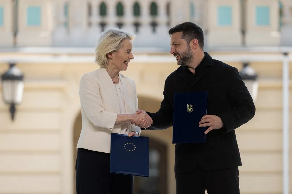This handout photograph taken and released by the Ukrainian Presidential Press Service on July 15, 2026, shows Ukraine's President Volodymyr Zelensky and European Commission President Ursula von der Leyen shaking hands as they hold signed bilateral documents following their meeting in Kyiv, amid the Russian invasion of Ukraine. (Photo by Handout / UKRAINIAN PRESIDENTIAL PRESS SERVICE / AFP) / RESTRICTED TO EDITORIAL USE - MANDATORY CREDIT "AFP PHOTO / Ukrainian Presidential Press Service" - NO MARKETING NO ADVERTISING CAMPAIGNS - DISTRIBUTED AS A SERVICE TO CLIENTS