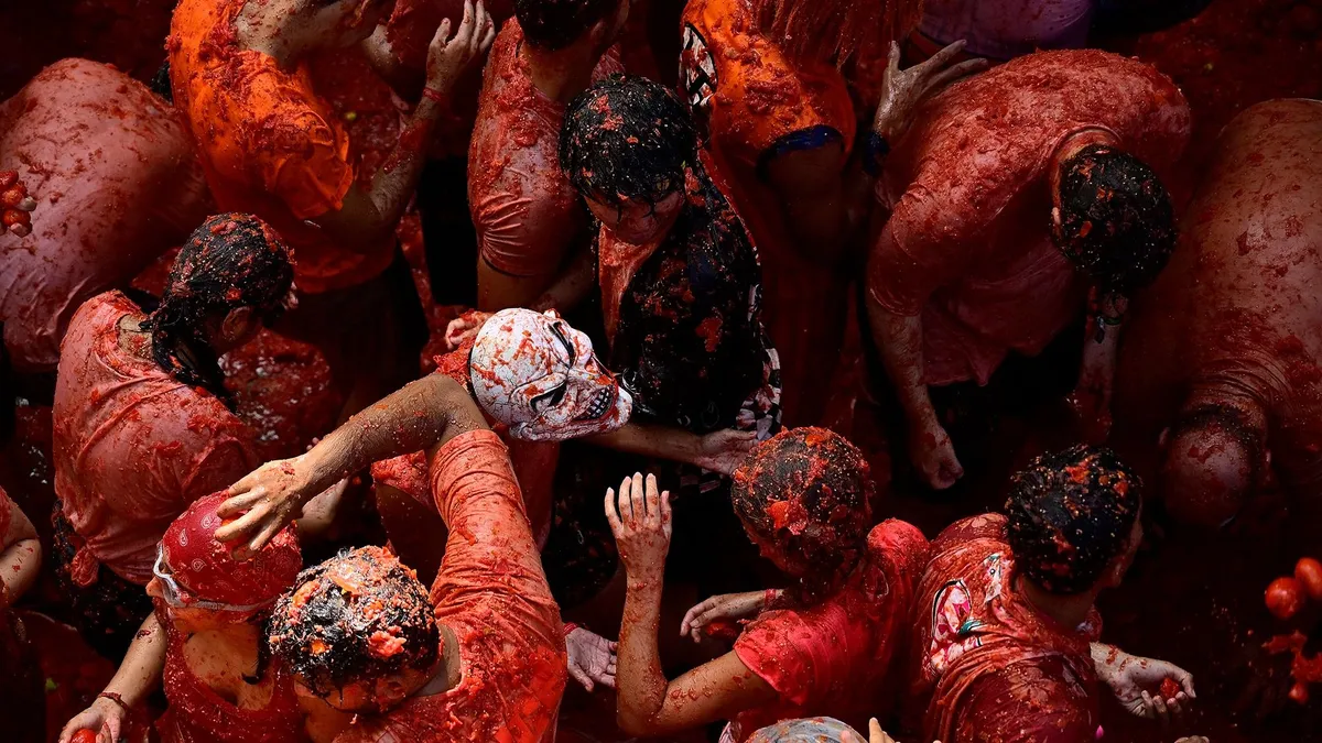 A La Tomatina paradicsomfesztiválon 22 ezer ember és 150 tonna paradicsom lepte el Buñol utcáit. Képeken a spanyolországi paradicsomcsata., Revellers participate in the "Tomatina" annual food-battle in the Spanish eastern town of Bunol, on August 26, 2026. (Photo by Jose JORDAN / AFP)