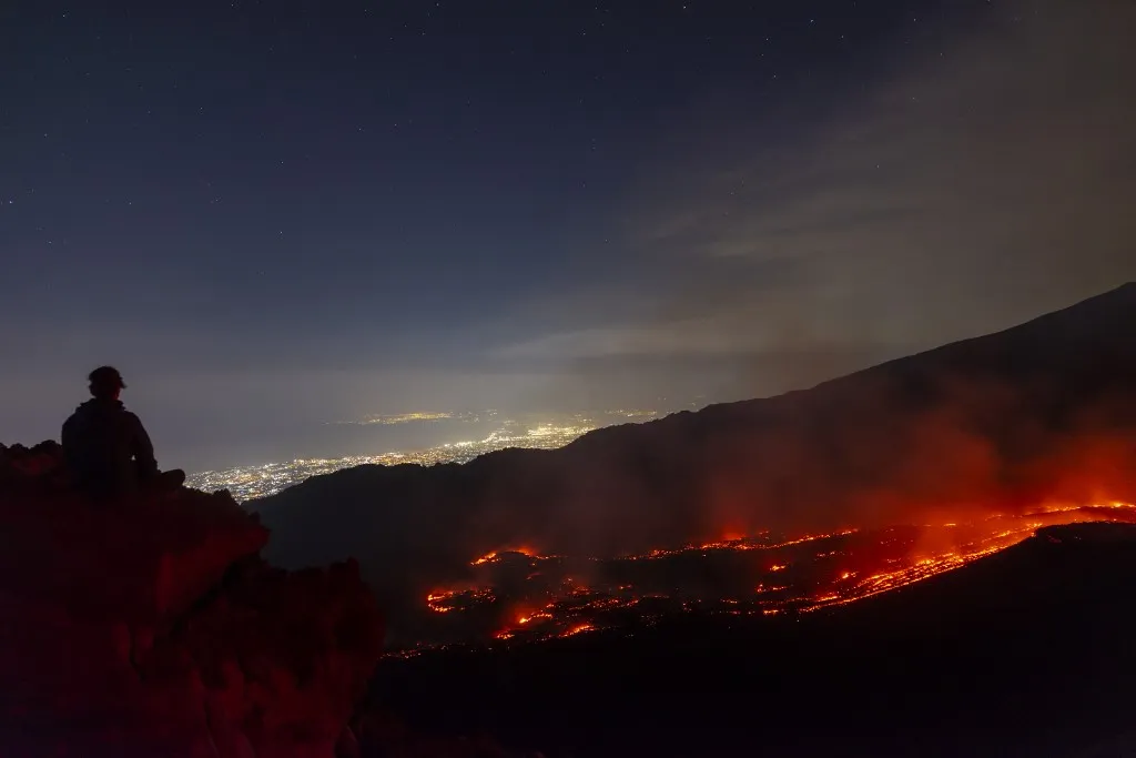 CATANIA, ITALY - AUGUST 8: Mount Etna enters a new paroxysmal phase characterized by intense activity at the Voragine summit crater in Catania, Sicily, Italy on August 8, 2026. The volcanic activity, which began to rapidly intensify during the evening of August 6, evolved into a powerful lava fountain overnight and into August 7. The eruption generated a significant ash cloud dispersing towards the southeast, with ashfall reported in the surrounding towns of Ragalna and Adrano. Additionally, a new lava flow was observed in the Valle del Leone from a new eruptive vent opened at an altitude of approximately 2750. The presence of volcanic ash and the elevation of the aviation alert to red severely impacted operations at Catania International Airport, leading to the temporary suspension and diversion of arriving flights. Salvatore Allegra / Anadolu (Photo by Salvatore Allegra / Anadolu via AFP)