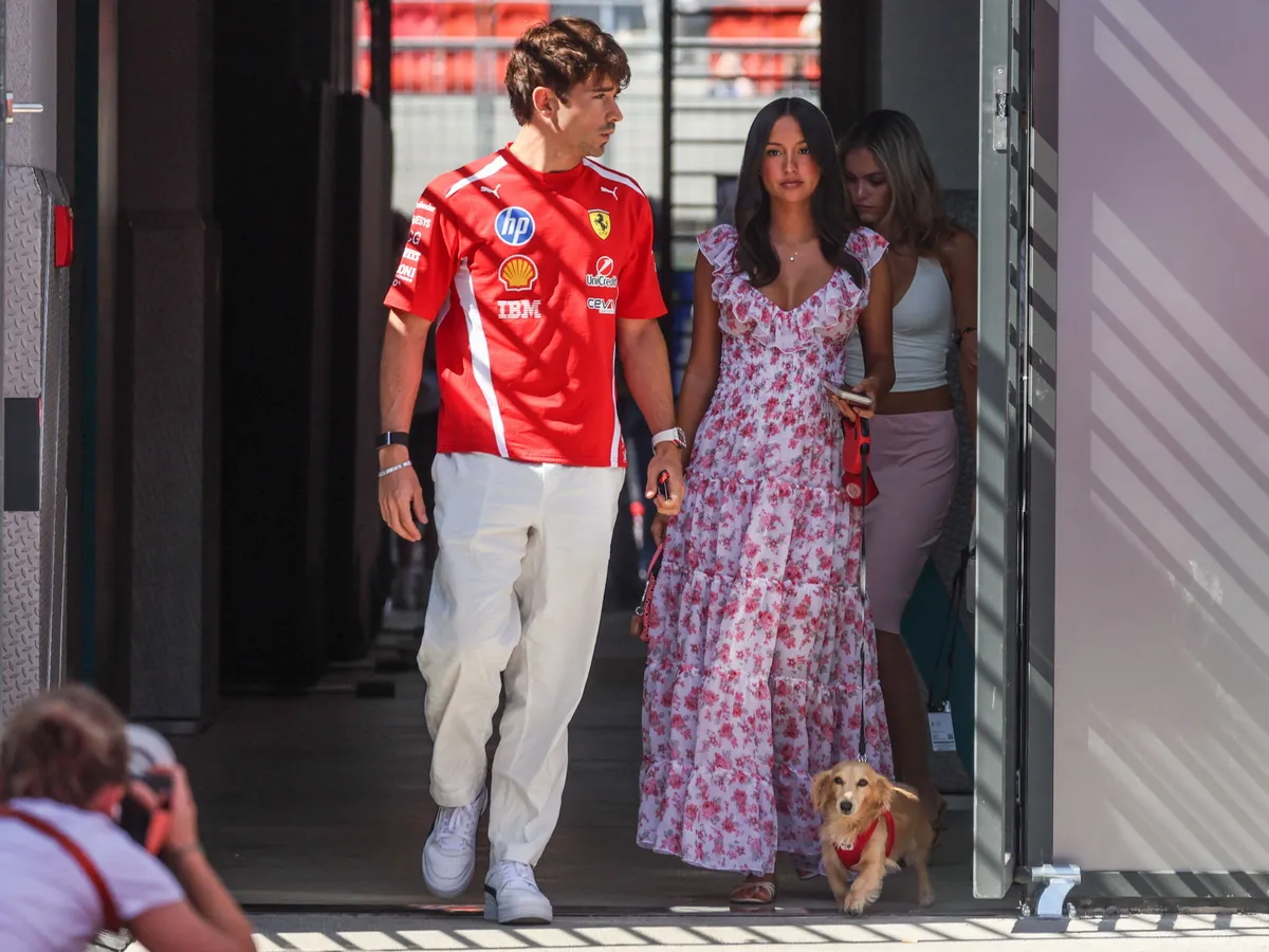 Charles Leclerc of Ferrari and his wife Alexandra Leclerc walk with their dog Leo through the paddock prior to final practice ahead Formula 1 Hungarian Grand Prix at the Hungaroring circuit in Mogyorod near Budapest on July 25th, 2026. (Photo by Beata Zawrzel/NurPhoto) (Photo by Beata Zawrzel / NurPhoto via AFP)