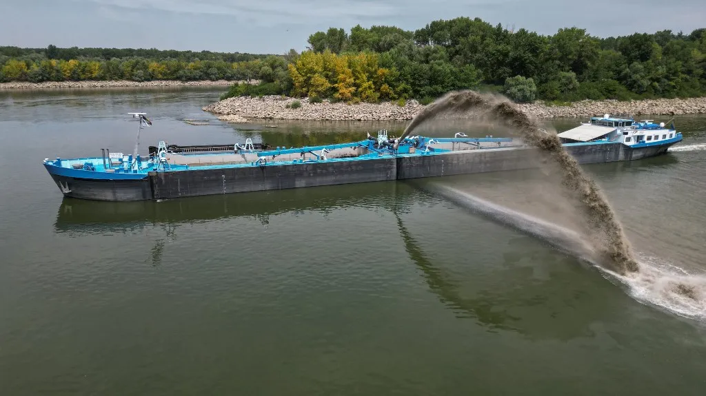 An aerial view shows a dredge ship at the splitting point of Danube with Bala branch and Old Danube, the place where a controlled underwater explosion took place on the riverbed of the Danube River in Izvoarele village, on August 3, 2026. The blast aimed at deepening the channel and diverting a higher volume of water toward the cooling systems of the Cernavoda Nuclear Power Plant. Local authorities and plant engineers authorized the blasting operations to counteract critically low water levels caused by a prolonged summer heatwave, ensuring the continuous and safe operation of the facility's reactors. (Photo by Daniel MIHAILESCU / AFP)