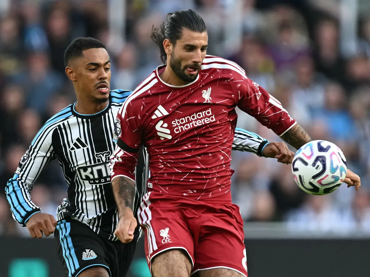 Newcastle United's English midfielder #41 Jacob Ramsey (L) vies with Liverpool's Hungarian midfielder #08 Dominik Szoboszlai (R) during the English Premier League football match between Newcastle United and Liverpool at St James' Park in Newcastle-upon-Tyne, north east England on August 23, 2026. (Photo by Paul ELLIS / AFP) / RESTRICTED TO EDITORIAL USE. No use with unauthorized audio, video, data, fixture lists, club/league logos or 'live' services. Online in-match use limited to 120 images. An additional 40 images may be used in extra time. No video emulation. Social media in-match use limited to 120 images. An additional 40 images may be used in extra time. No use in betting publications, games or single club/league/player publications. /