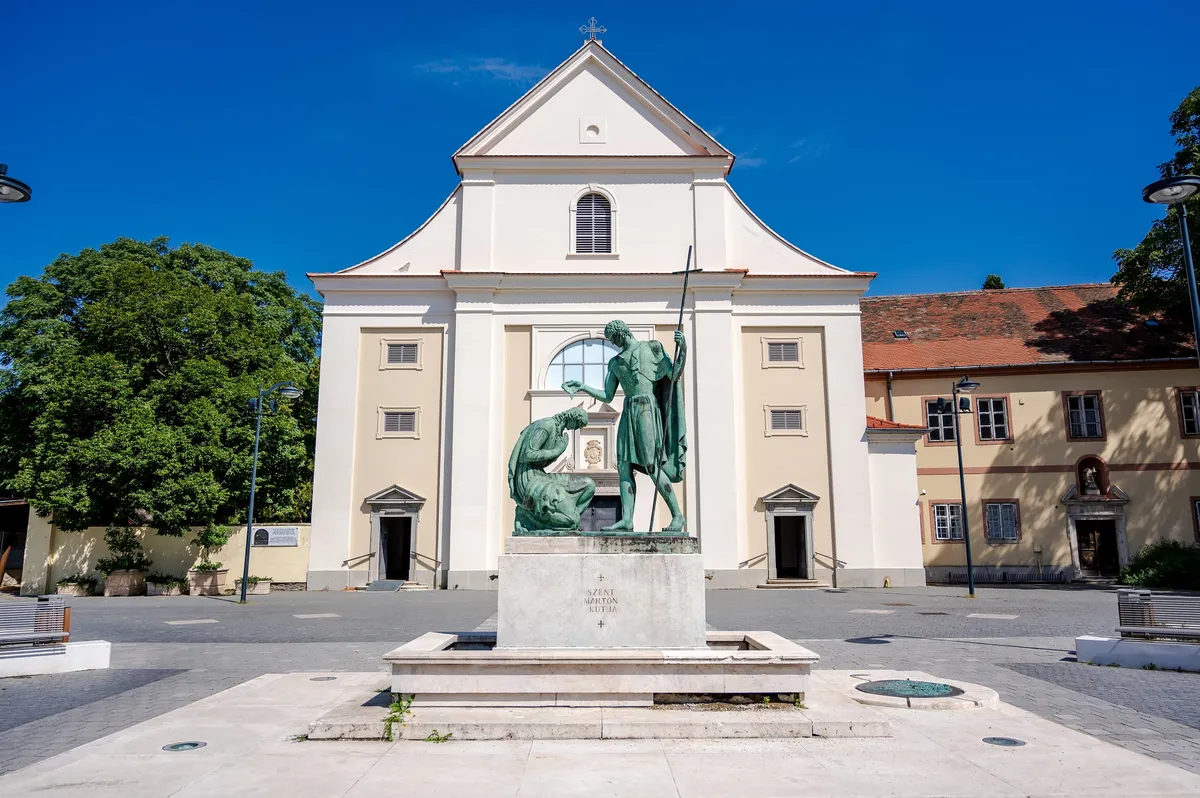 A szombathelyi Szent Márton-templom és előtte a szentet ábrázoló szoborcsoport.