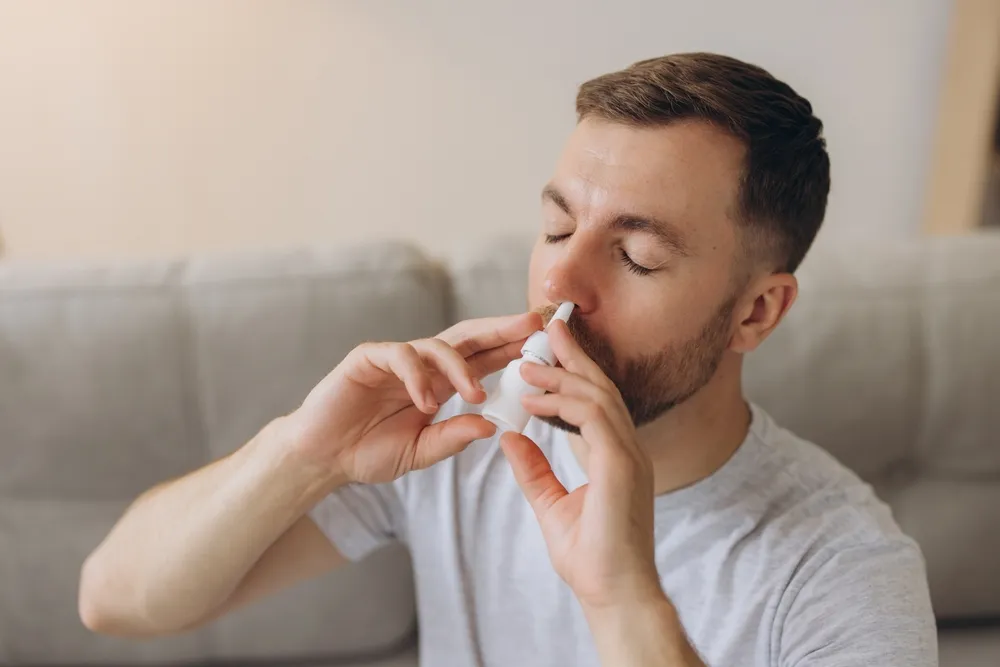 Asztmás férfi inhalátort használ