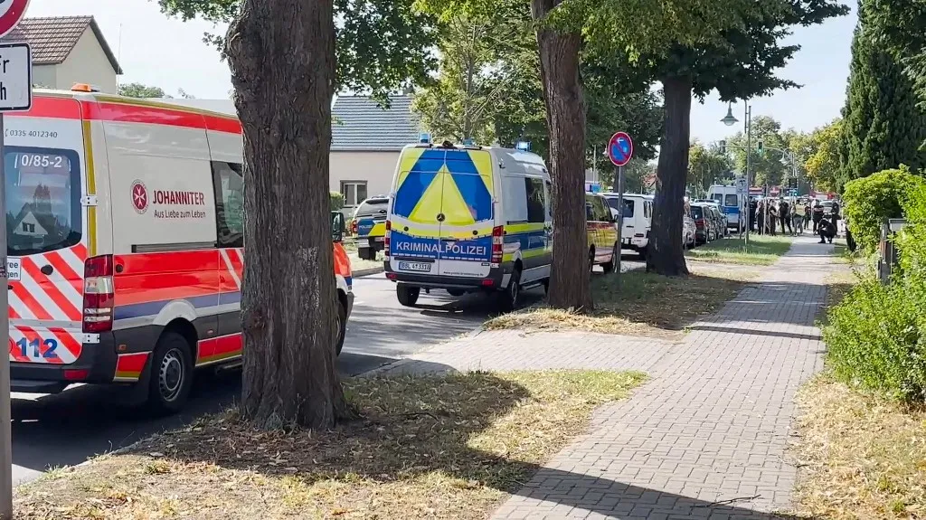 27 August 2026, Brandenburg, Gosen-Neu Zittau: An ambulance and police cars are parked in front of a school. According to the German Press Agency, a woman and a man were killed in a violent incident at a school in Gosen-Neu Zittau. A suspect has been taken into custody. Photo: Moritz Deckwerth/dpa (Photo by Moritz Deckwerth / dpa Picture-Alliance via AFP)