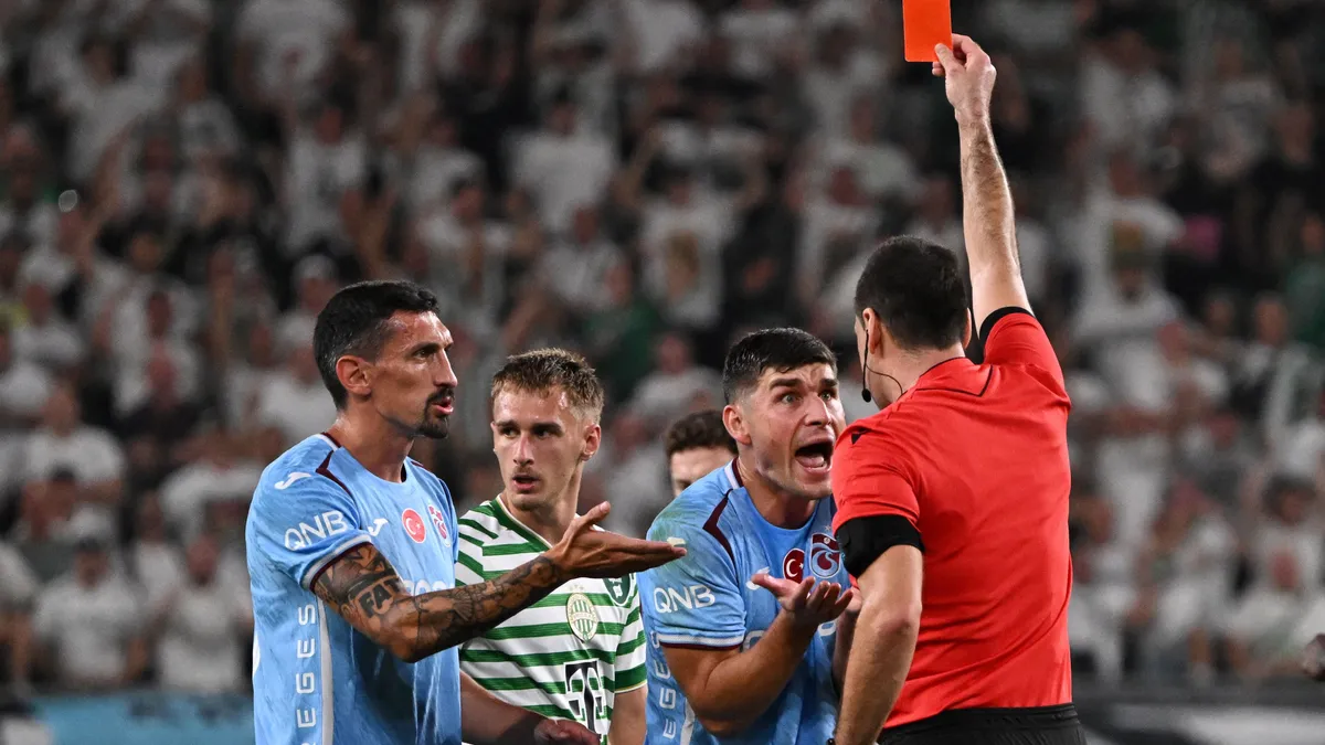 Trabzonspor's Ukrainian midfielder #17 Ruslan Malinovskyi (2R) is shown the red card by the referee during the UEFA Europa League second leg playoff football match between Ferencvaros and Trabzonspor in Budapest on August 27, 2026. (Photo by Attila KISBENEDEK / AFP)