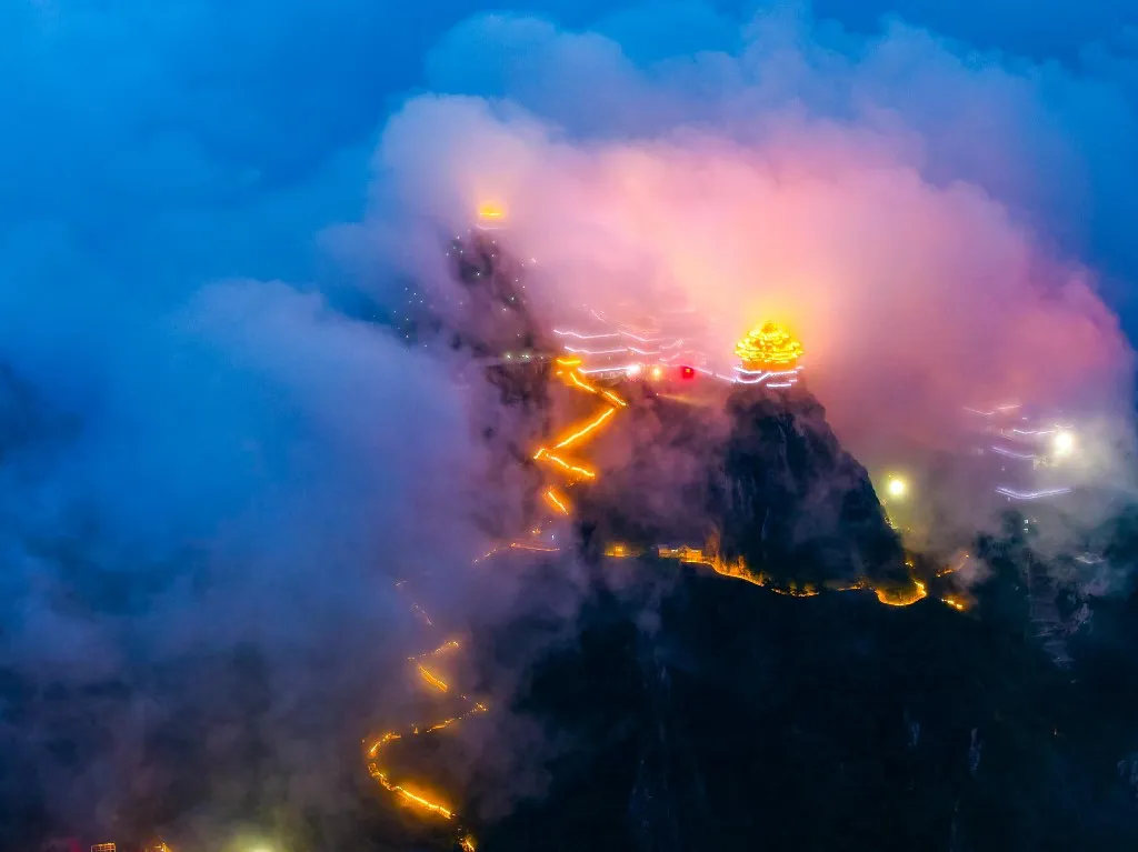 A sea of clouds rolls over Laojun Mountain in Luoyang, central China's Henan province, on the evening of July 6, 2026, with golden palace roofs floating above the mist, creating a dreamy fairy-tale scene. (Photo by IC photo / Imaginechina via AFP)