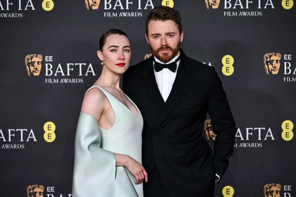 US-Irish actor Saoirse Ronan and Scottish actor Jack Lowden (R) pose on the red carpet upon arrival at the BAFTA British Academy Film Awards at the Royal Festival Hall, Southbank Centre, in London, on February 16, 2025. (Photo by Ben STANSALL / AFP)