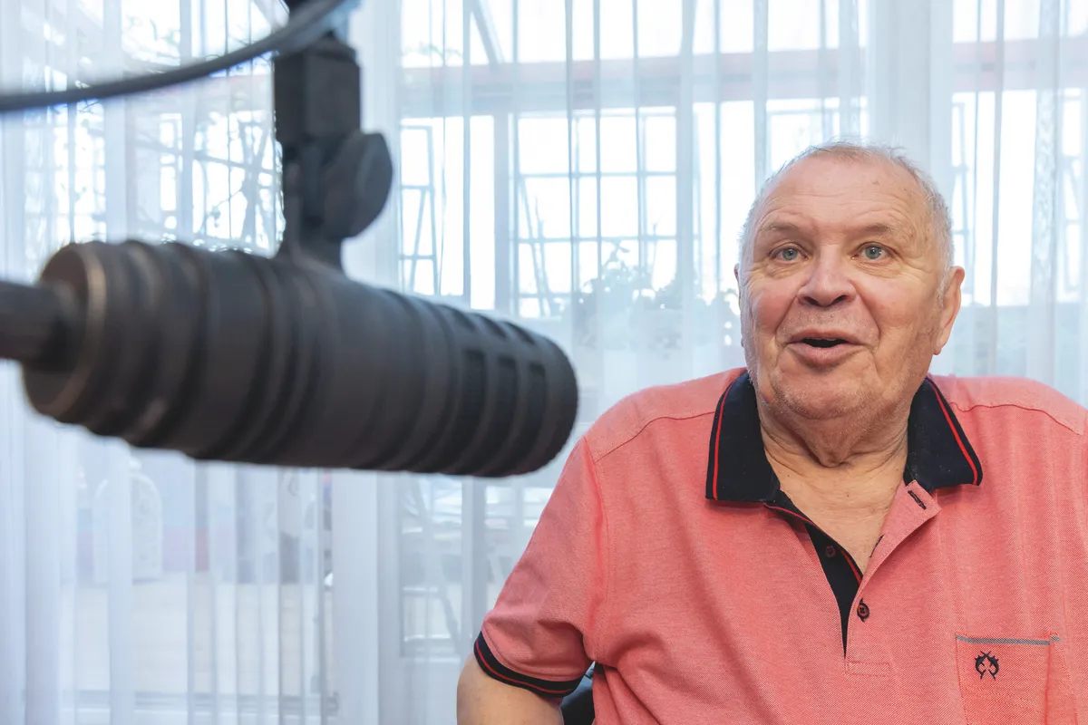 Dévényi Tibor a rádiós mikrofonba beszél.