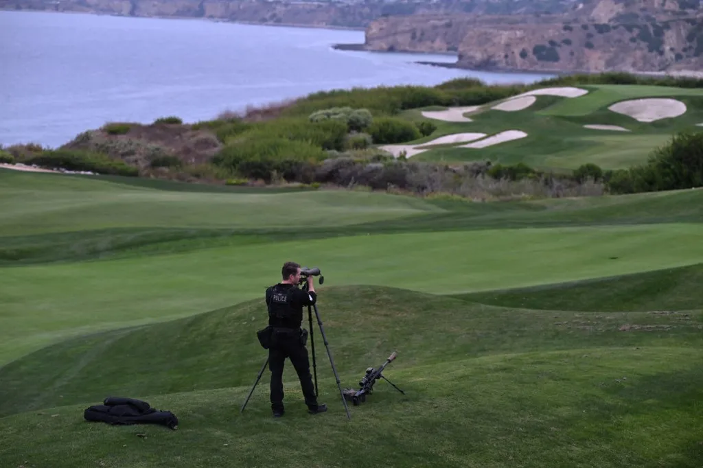 (FILES) A US Secret Service agent mans his post before former US President and Republican presidential candidate Donald Trump speaks at a press conference at Trump National Golf Club Los Angeles in Rancho Palos Verdes, California, on September 13, 2024. An armed man was arrested at President Donald Trump's golf course near Los Angeles two days before the US leader's visit the local sheriff's office said on August 4, 2026. The man, identified as a 38-year-old from nearby Downey, California, was spotted by plainclothes federal agents "walking throughout the golf course grounds taking photographs and videos and appearing to monitor security-planning activities." (Photo by Robyn Beck / AFP)