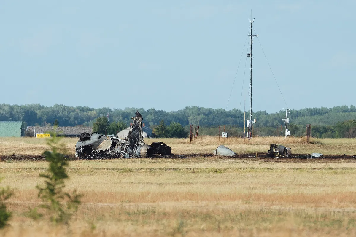 SZOLNOK, HUNGARY - AUGUST 24: The remains of the Hungarian Air Force JAS 39 Gripen fighter jet after it crashed at the military base in Szolnok, Hungary, on Monday, August 24, 2026. The pilot ejected from the aircraft and was taken to hospital for observation; his condition was reported as stable. The crash occurred on military property, and the circumstances are under investigation. Robert Nemeti / Anadolu (Photo by Robert Nemeti / Anadolu via AFP)