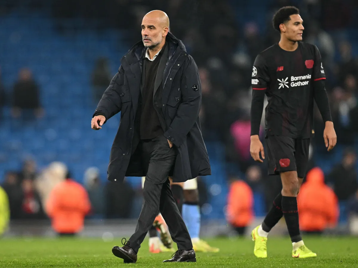 Manchester City's Spanish manager Pep Guardiola (C) on the pitch after the UEFA Champions League league-stage football match between Manchester City and Bayer Leverkusen at the Etihad Stadium in Manchester, north west England, on November 25, 2025. Leverkusen won the game 2-0. (Photo by Oli SCARFF / AFP)