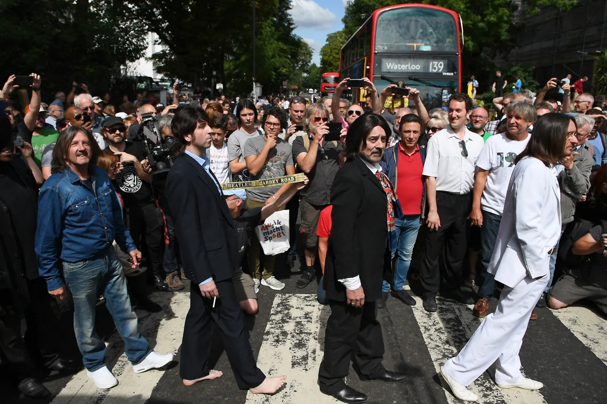 Rajongók az Abbey Roadon, valamint egy Beatles-feldolgozászenekar, akik épp újraalkotják az ikonikus lemezborítót