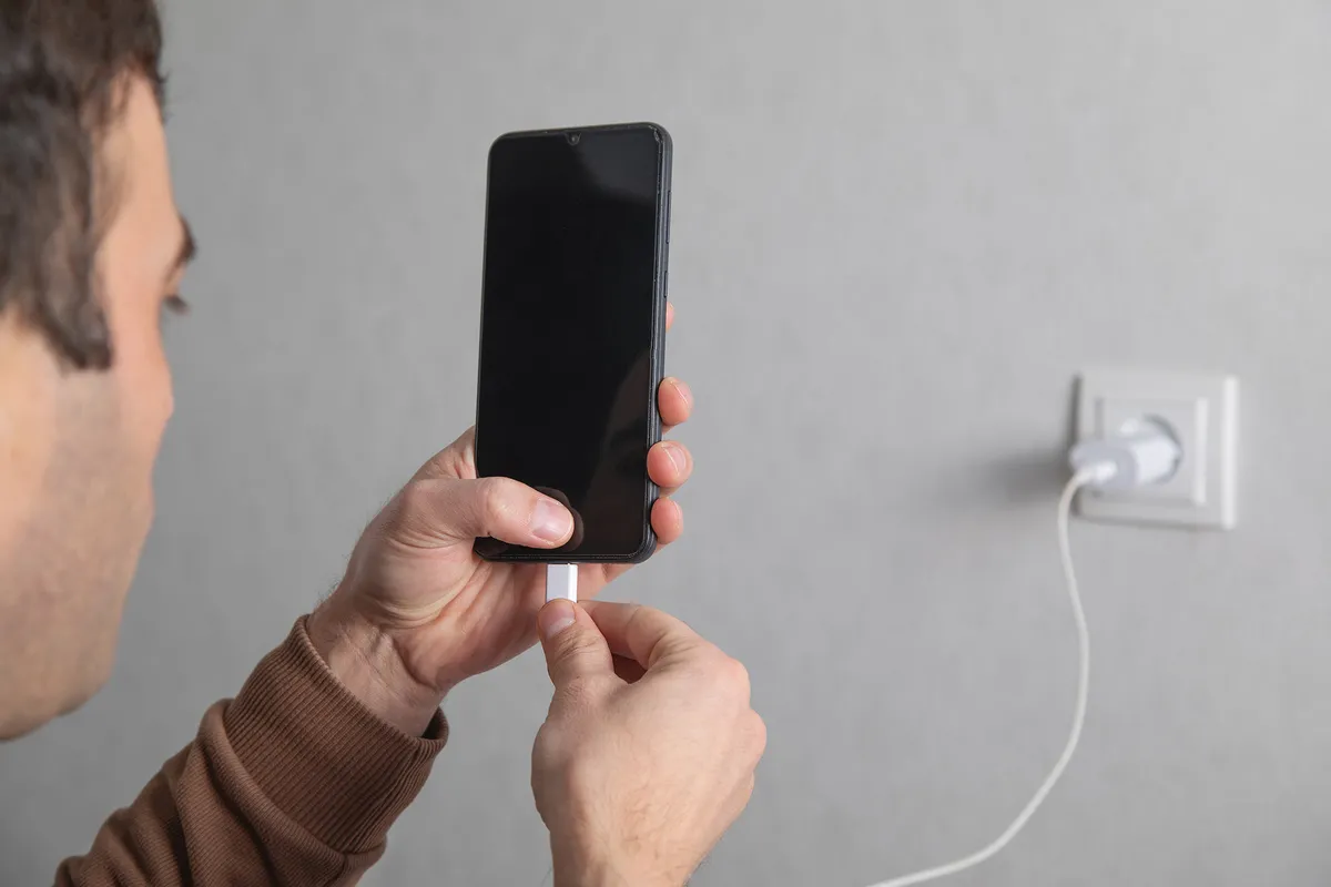 Man connect cable to smartphone. Charging
