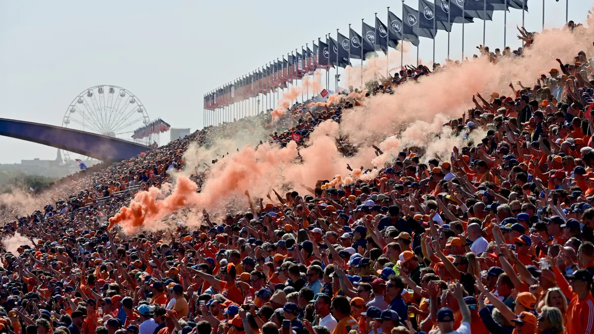 (FILES) Fans burn orange flares during the drivers' parade at the Zandvoort circuit before the start of the Netherlands' Formula One Grand Prix in Zandvoort on September 5, 2021. For three days a year, the quiet residential street of Van Speijkstraat in the sleepy Dutch beach resort of Zandvoort transforms itself into a sea of orange streamers and chequered flags, welcoming Formula One fans from around the world. (Photo by ANDREJ ISAKOVIC / AFP)