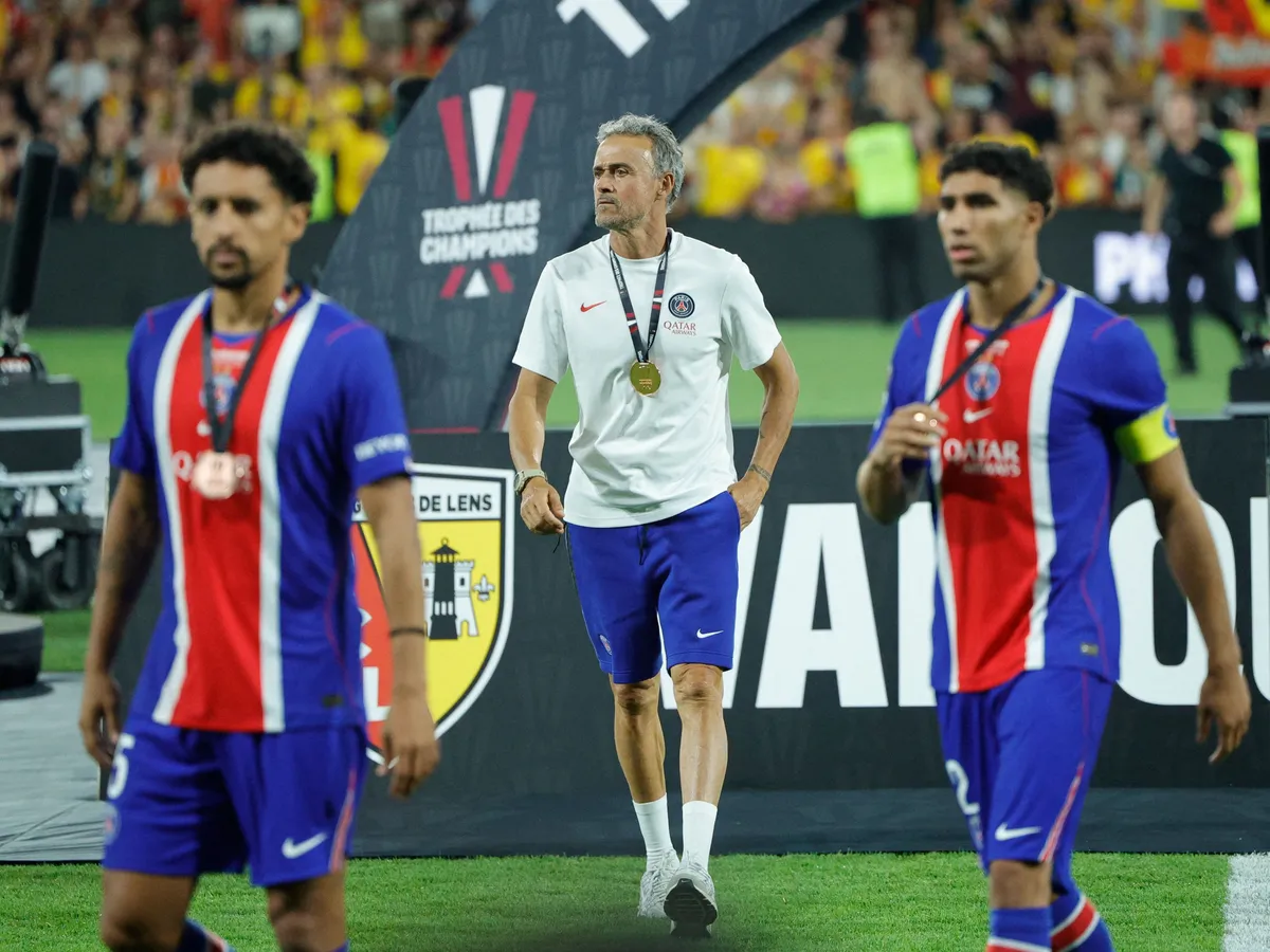 (From L) PSG's Brazilian defender #05 Marquinhos, PSG's Spanish headcoach Luis Enrique and PSG's Moroccan defender #02 Achraf Hakimi walk out with their silver medals after losing the French Super Cup (Trophee des Champions) football match between RC Lens and Paris Saint-Germain (PSG) at the Stade Bollaert-Delelis in Lens, northern France on August 16, 2026. (Photo by GEOFFROY VAN DER HASSELT / AFP)