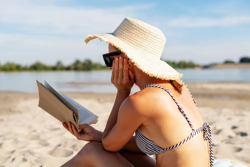 Tájverset olvasó nő a strandon