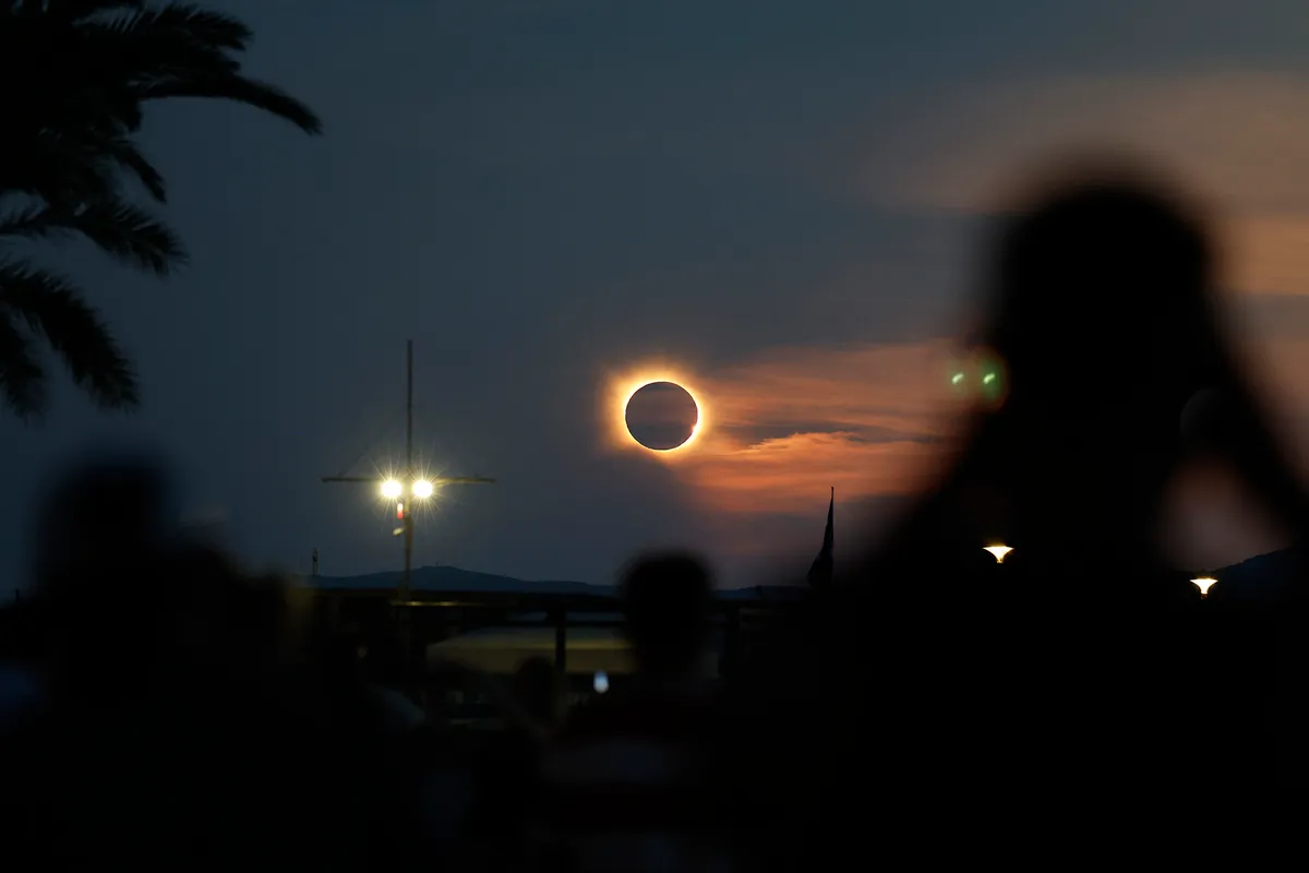 The Sun's corona glows as the Moon completely blocks the Sun during the totality phase of the total solar eclipse as seen from Arenal beach in Llucmajor, on the Balearic island of Mallorca, on August 12, 2026. Millions of Europeans contemplated the sky in awe today during a rare total solar eclipse that will plunge a swathe of Spain into an eerie daytime darkness. The shadow cast when the Moon covers the Sun began in Russia's remote Arctic north at around 1700 GMT and continued in an arc through Greenland and Iceland. Spain is where most people viewed the total eclipse, which crossed the country diagonally from the northern Atlantic coast to the Mediterranean Sea, where it vanished at around 1830 GMT. (Photo by Jaime REINA / AFP), napfogyatkozás