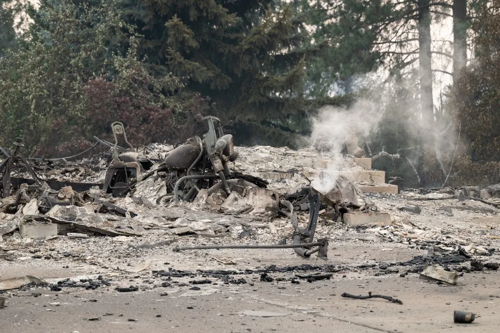 A washingtoni erdőtűz után kiégett épületek és járművek maradtak hátra Fotó: ERICK DOXEY / AFP A burned motorcycle sits in the ashes of burned out residential home in the Balboa neighborhood of Spokane, Washington, on August 2, 2026. Fast-moving fires left a trail of destruction in the northwestern US city of Spokane on Sunday, with officials reporting hundreds of structures reduced to cinders.Thousands of people were ordered to evacuate their homes Saturday and overnight into Sunday, as three separate fires broke out in and around the city in the east of Washington state. (Photo by Erick Doxey / AFP)