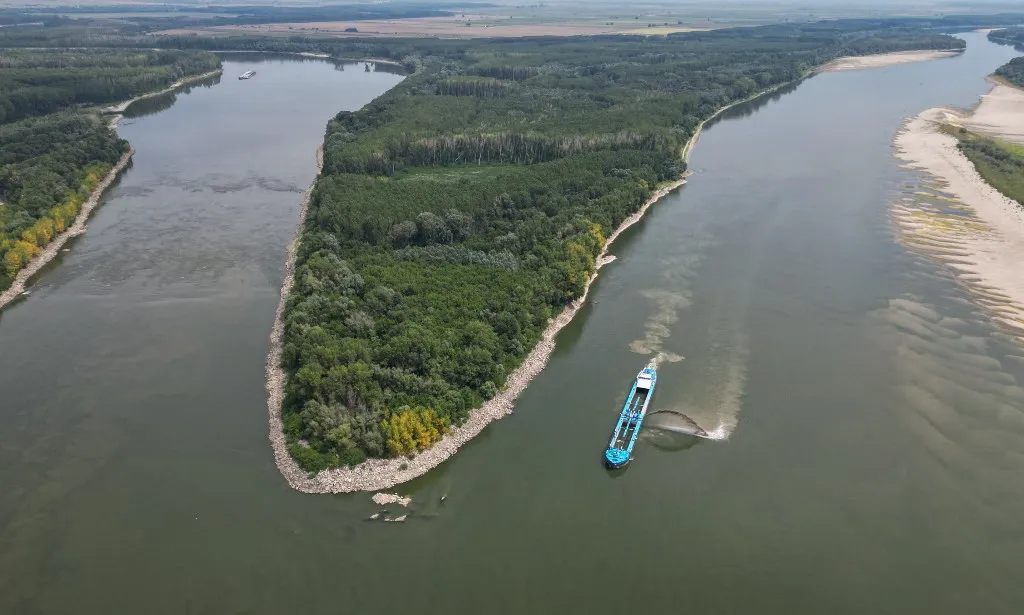 Duna, An aerial view shows a dredge ship at the splitting point of Danube with Bala branch and Old Danube, the place where a controlled underwater explosion took place on the riverbed of the Danube River in Izvoarele village, on August 3, 2026. The blast aimed at deepening the channel and diverting a higher volume of water toward the cooling systems of the Cernavoda Nuclear Power Plant. Local authorities and plant engineers authorized the blasting operations to counteract critically low water levels caused by a prolonged summer heatwave, ensuring the continuous and safe operation of the facility's reactors. (Photo by Daniel MIHAILESCU / AFP)