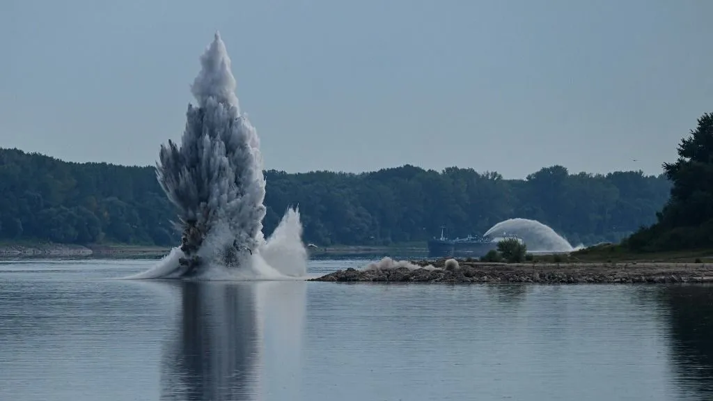 A controlled underwater explosion is pictured on the riverbed of the Danube River in Izvoarele village, on August 3, 2026. The blast aimed at deepening the channel and diverting a higher volume of water toward the cooling systems of the Cernavoda Nuclear Power Plant. Local authorities and plant engineers authorized the blasting operations to counteract critically low water levels caused by a prolonged summer heatwave, ensuring the continuous and safe operation of the facility's reactors. (Photo by Daniel MIHAILESCU / AFP)